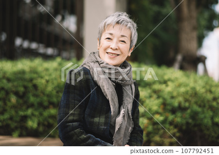 一位優雅的日本女商人,頭髮灰白,坐在街角 一位優雅的日本女商人,頭髮灰白,坐在街角 107792451