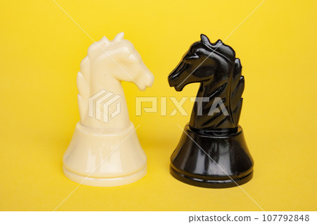 Selective view of knight chess moving toward for battle with yellow cover background. Strategy and tactic concept 107792848