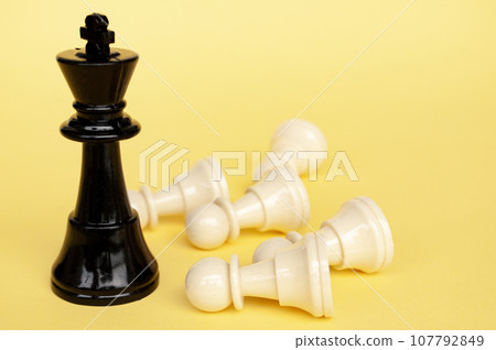 Selective view of chess king defeated white pawn with yellow cover background. Strategy and tactic concept 107792849