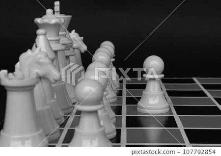 Selective view of chess pawn moving toward for battle with black and white background. Strategy and tactic concept Selective view of chess pawn moving toward for battle with black and white background. Strategy and tactic concept 107792854