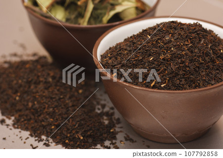 Two cups of dry high quality tea leaves. 107792858