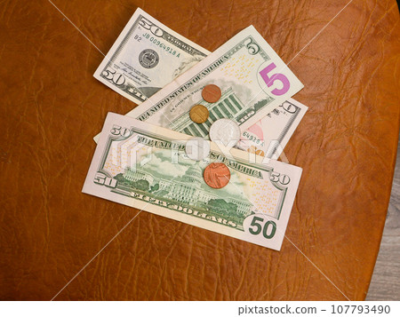 Coins on the background of dollar bills top view. Coins on the background of dollar bills top view. 107793490