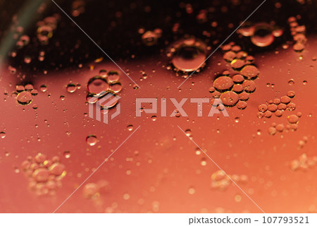 oil with bubbles on orange background. Abstract space background. Soft selective focus. macro of oil drops on water surface. copy space. air bubbles in water oil with bubbles on orange background. Abstract space background. Soft selective focus. macro of oil drops on water surface. copy space. air bubbles in water 107793521