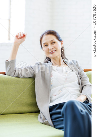 Senior woman relaxing on the sofa in the living room Senior woman relaxing on the sofa in the living room 107793620