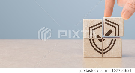 Protection health and life insurance concept. Care for employees. Hand puts wooden cubes with shield protect and tick mark. copy space. Protection health and life insurance concept. Care for employees. Hand puts wooden cubes with shield protect and tick mark. copy space. 107793651