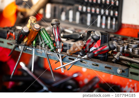 Screwdrivers and other work tools on workbench in garage Screwdrivers and other work tools on workbench in garage 107794185