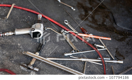 Many auto mechanic tools on concrete floor in the garage 107794186