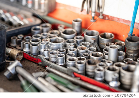 Pieces of drive socket wrench set on the workbench 107794204