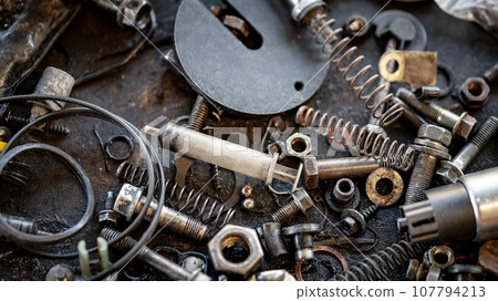 Pieces of rusty spare part and scattered scrap materials Pieces of rusty spare part and scattered scrap materials 107794213