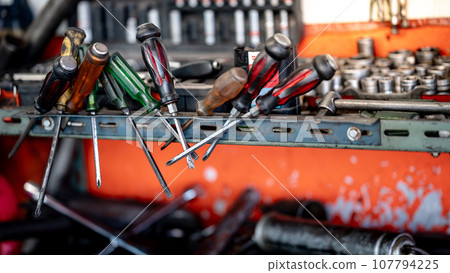 Screwdrivers and other work tools on workbench in garage Screwdrivers and other work tools on workbench in garage 107794225