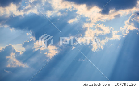 The background of sun rays over clouds. The sun rays break over the clouds. 107796120