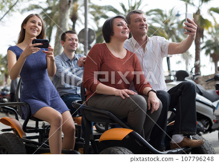 Family of tourists enjoy a walk on the bike carriage Family of tourists enjoy a walk on the bike carriage 107796248