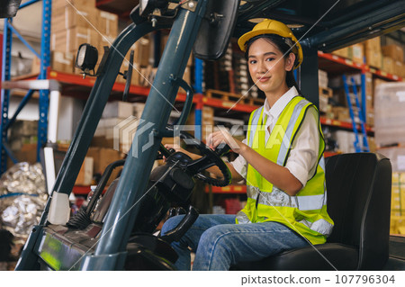 Forklift driver young staff lady worker in warehouse logistics loading cargo products storage industry Forklift driver young staff lady worker in warehouse logistics loading cargo products storage industry 107796304