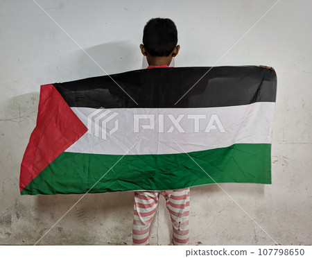 A boy is holding a palastine flag as a sign of support A boy is holding a palastine flag as a sign of support 107798650
