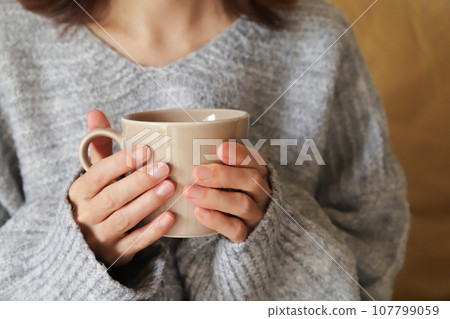 Woman holding a mug 107799059