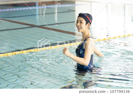 woman walking in indoor pool woman walking in indoor pool 107799136