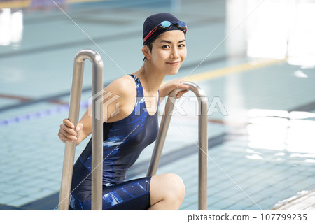 Young woman getting out of the indoor pool Young woman getting out of the indoor pool 107799235