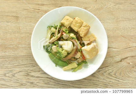 stir fried slice cabbage broccoli with green pea and straw mushroom couple dice tofu in soy sauce vegetarian food on plate   107799965