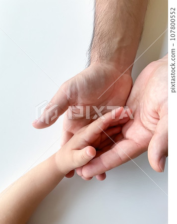Adult and child hold their hands together. Fathers Day Child gives hand to adult 107800552