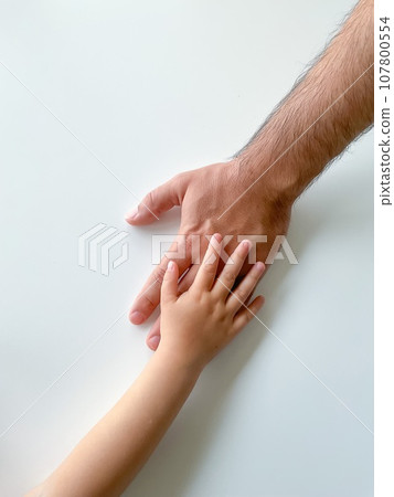 Adult and child hold their hands together. Fathers Day Child gives hand to adult 107800554