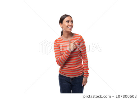a young caucasian woman with black hair dressed in a striped orange jacket gesticulates with her 107800608