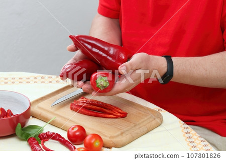 Man's hands holding ripe red peppers 107801826