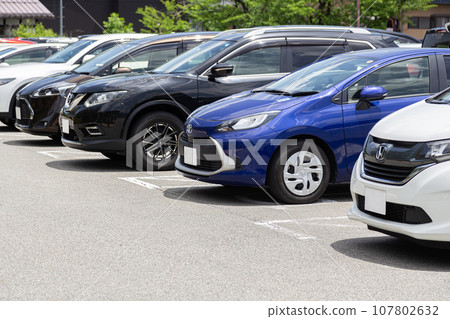 Cars lined up in a parking lot Cars lined up in a parking lot 107802632