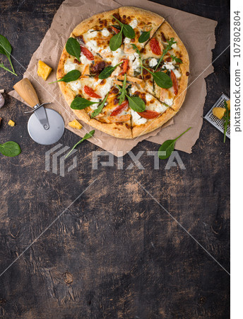 Italian pizza with feta cheese, tomato and basil Italian pizza with feta cheese, tomato and basil 107802804