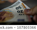 Hand and euro bank notes close up 107803366