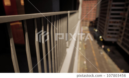 A building with a scenic view of the city captured through a close-up of a fence 107803456