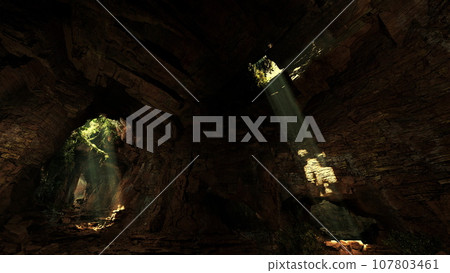 A cave illuminated by a mesmerizing volume of light shining through rocks 107803461