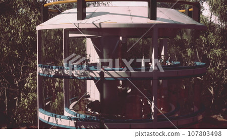 A modern water tower nestled among a vibrant forest scenery 107803498