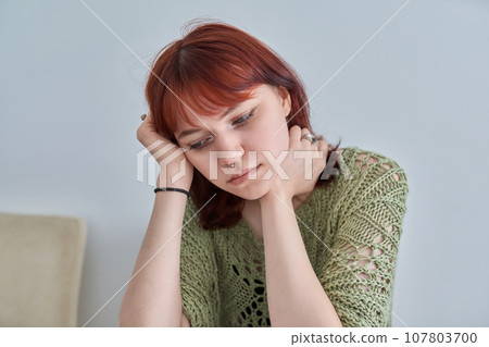Sad upset teenage female, red-haired girl 19, 20 years old face close-up Sad upset teenage female, red-haired girl 19, 20 years old face close-up 107803700