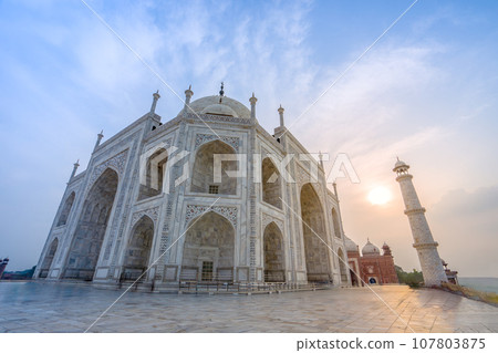 Side view of the Taj Mahal's white domes and white towers at sunset. Side view of the Taj Mahal's white domes and white towers at sunset. 107803875
