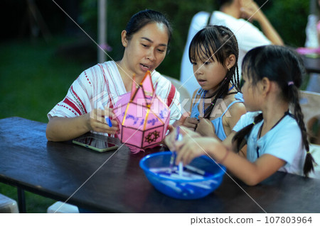 Asian families make wishes and hang lanterns during The Hundred Thousand Lantern Festival or Yi Peng Festival in northern Thailand. 107803964