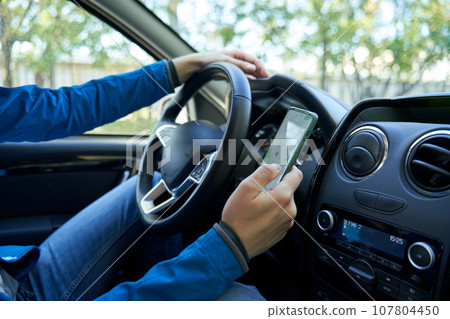 Man driving car using smartphone in motion. Man driving car using smartphone in motion. 107804450