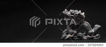 Gray dragon statue on a black background. The symbol of 2024. 107804993