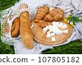 Picnic in the field with berries, juice, cheese, sausage and sweet croissants 107805182