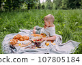 Boy child preschooler on a picnic. Smiles, eating cherries and enjoying summer. 107805184