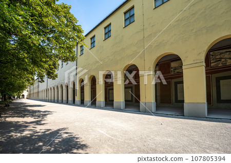 Promenade with long arcade columns surrounding Hofgarten Park in Munich, Germany 107805394
