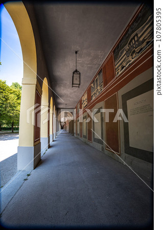 Promenade with long arcade columns surrounding Hofgarten Park in Munich, Germany 107805395