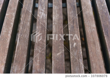 Brown wooden bench made of smooth beams. 107806078