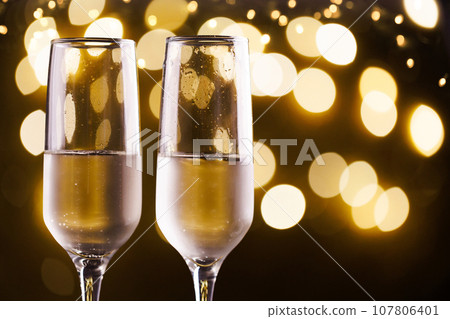 Two New Year's glasses of champagne with highlights on a colored background 107806401