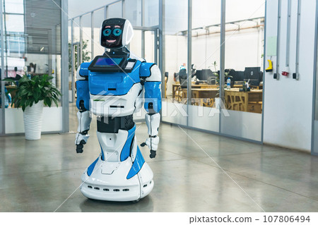 humanoid robot with a friendly face in the interior of a modern office 107806494
