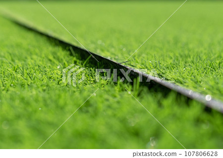 Artificial grass close-up. Artificial turf background. Artificial grass close-up. Artificial turf background. 107806628