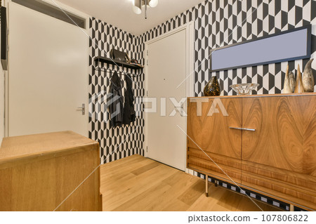 a bedroom with black and white patterned wallpaper on the walls, wooden furniture in the closet is next to the bed a bedroom with black and white patterned wallpaper on the walls, wooden furniture in the closet is next to the bed 107806822