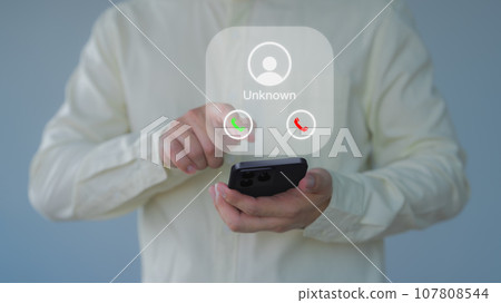 Man answering the incoming call. The phone call was from an unknown number. Hoax person with a fake identity. Call center gang or stranger. Concept of scam, fraud with smartphone from the criminal. 107808544