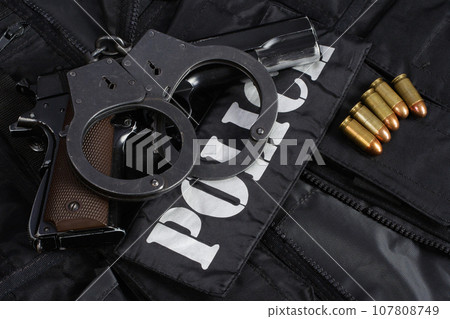 Police handgun with handcuffs on black uniform 107808749