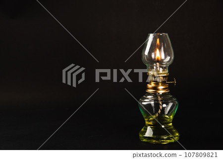 A captivating Diwali concept, An antique oil lamp at night against a black background, radiating a warm, glowing light. Perfect for festive greetings. A captivating Diwali concept, An antique oil lamp at night against a black background, radiating a warm, glowing light. Perfect for festive greetings. 107809821