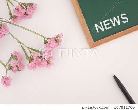 NEWS letters, flowers and pen on blackboard, with copy space 107811700